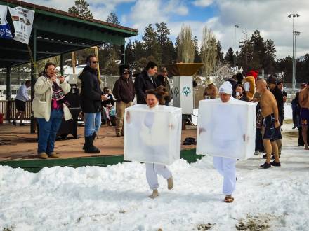 Asistentes disfrazados de cubitos de hielo corren por la nieve en la zambullida polar de Big Bear