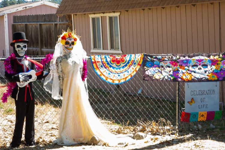 2025 Exposición de espantapájaros y Día de los Muertos: dos esqueletos, uno vestido de novia y otro de novio.