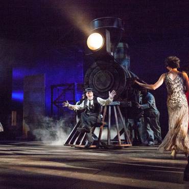 Una representación teatral de *Stoneface* a cargo del Big Bear Theatre Project: se ve a un hombre descansando en la parte delantera de un tren de vapor.