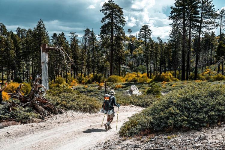 Una excursionista recorre un sendero durante el evento Highlander Adventure. Lleva una mochila con sus provisiones.