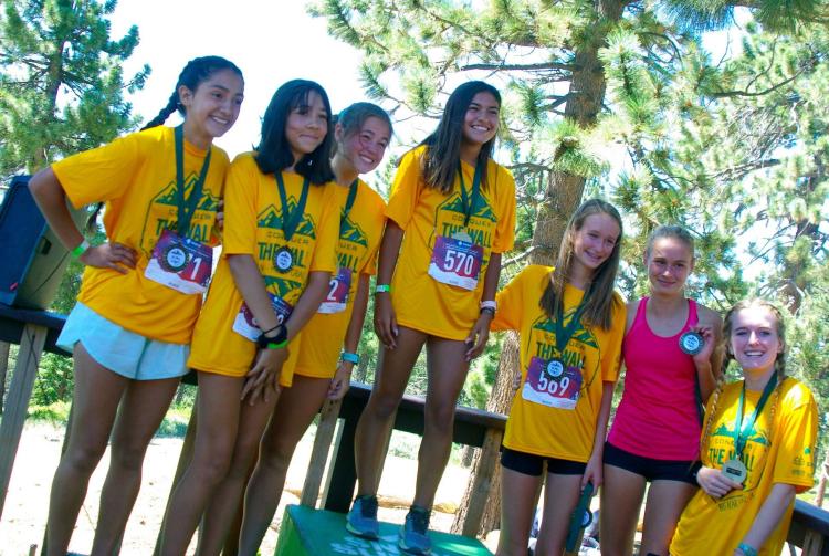 Un grupo de chicas con camisetas amarillas posan para los premios en el evento Conquer The Wall en Big Bear Lake California.