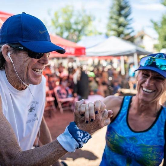 Un hombre y una mujer se cogen de la mano y sonríen en la Big Bear Lake Kodiak 100