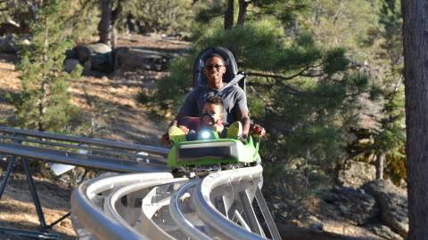 Un padre monta en la Mineshaft Coaster con su hija en Big Bear, California.