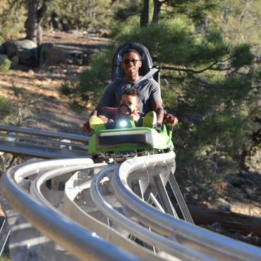 Un padre monta en la Mineshaft Coaster con su hija en Big Bear, California.