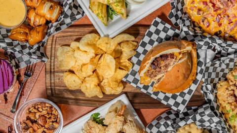 Vista desde arriba de la comida servida en la sala Moonridge: hay aperitivos alrededor de una hamburguesa con forma de platillo volante.