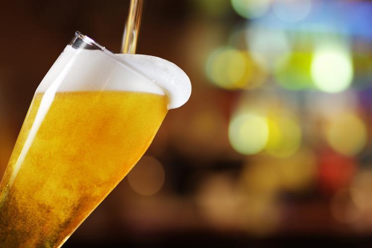 La cerveza ámbar se vierte en una jarra de cristal y se desborda.