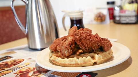 Pollo frito sobre gofre servido con sirope en Country Kitchen Food