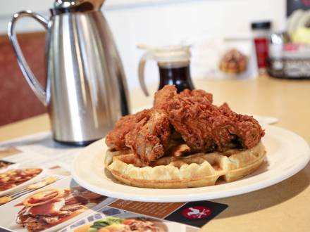 Pollo frito sobre gofre servido con sirope en Country Kitchen Food