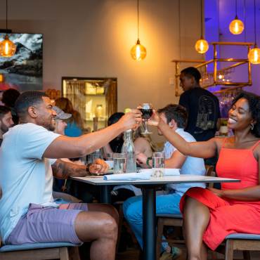 "Una pareja disfrutando de una comida juntos y levantando sus copas en un brindis en el restaurante Stella Luna en Big Bear"