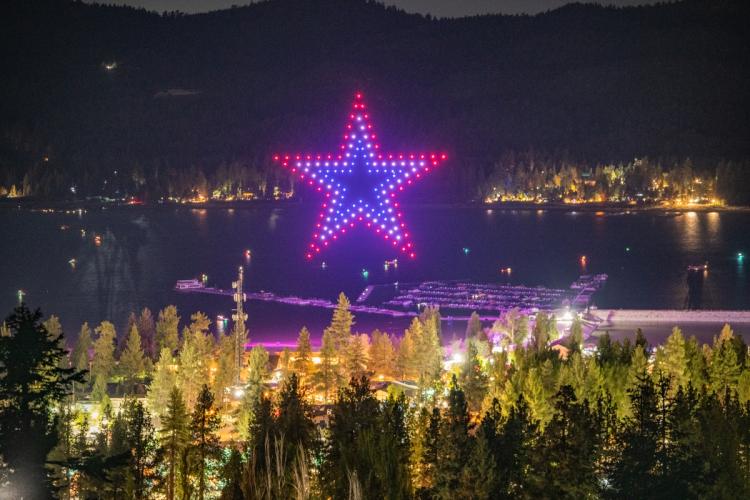 Una foto tomada desde lejos durante el espectáculo de drones del Día de los Caídos en Big Bear Lake, en la que se ve cómo unos drones dibujan el contorno de una estrella.