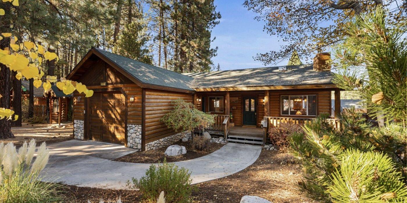 Una foto de una cabaña de madera situada en el bosque, cerca de Big Bear Cool Cabins.