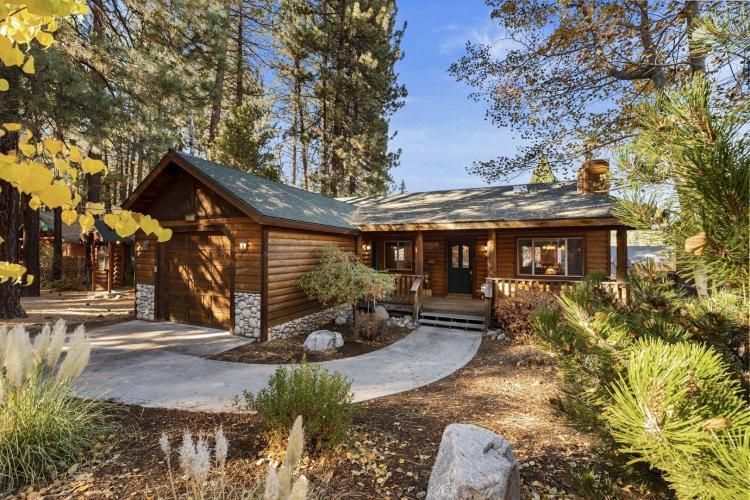 Una foto de una cabaña de madera situada en el bosque, cerca de Big Bear Cool Cabins.
