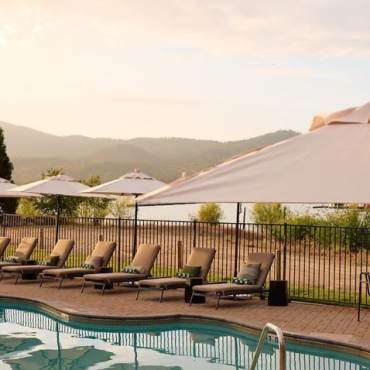 Una foto de la vista de la piscina del Hotel Marina Riviera, con el lago Big Bear al fondo y una suave puesta de sol.